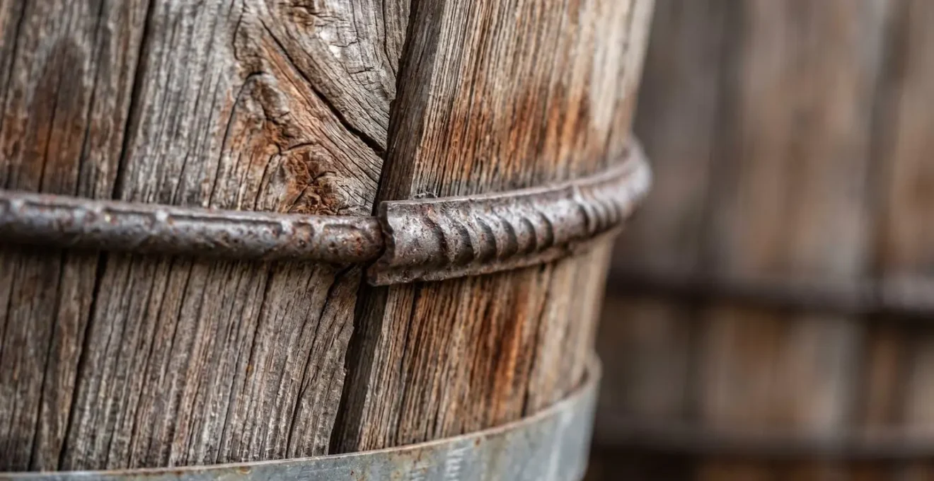 Extreme close-up of wooden water tank staves showing natural cedar grain texture and steel hoop tension bands