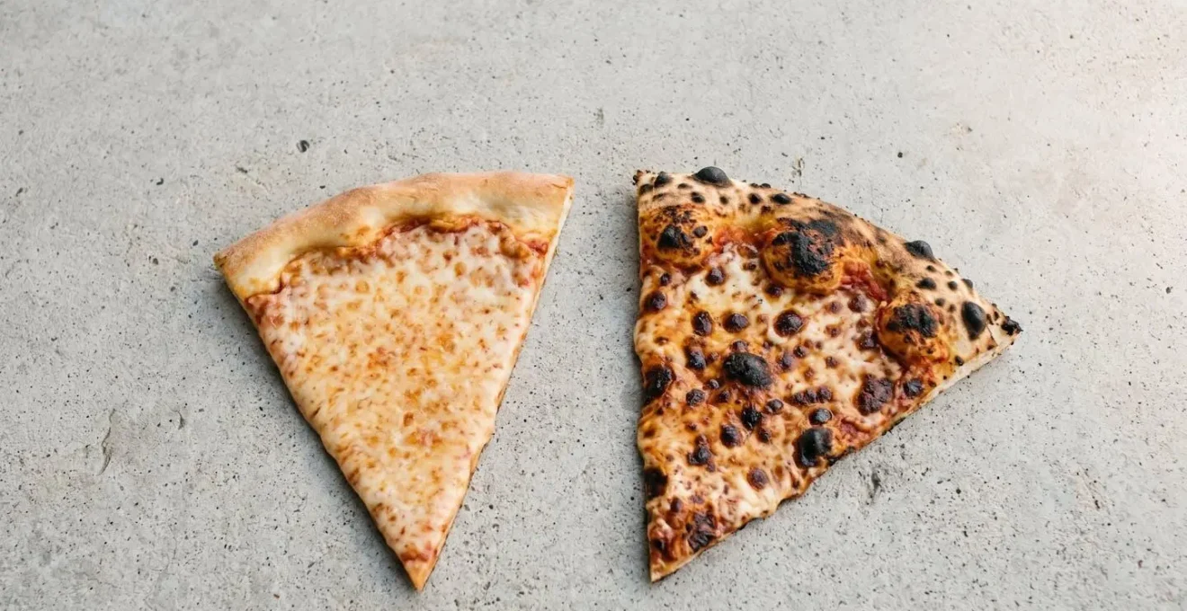 Macro detail of coal-fired pizza crust edge showing distinctive char marks, blistered surface texture, and leopard-spotted charring pattern characteristic of high-temperature baking